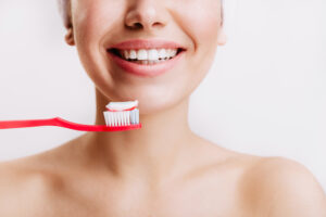Donna sorridente con spazzolino, immagine illustrativa per l’articolo sullo sbiancamento dentale